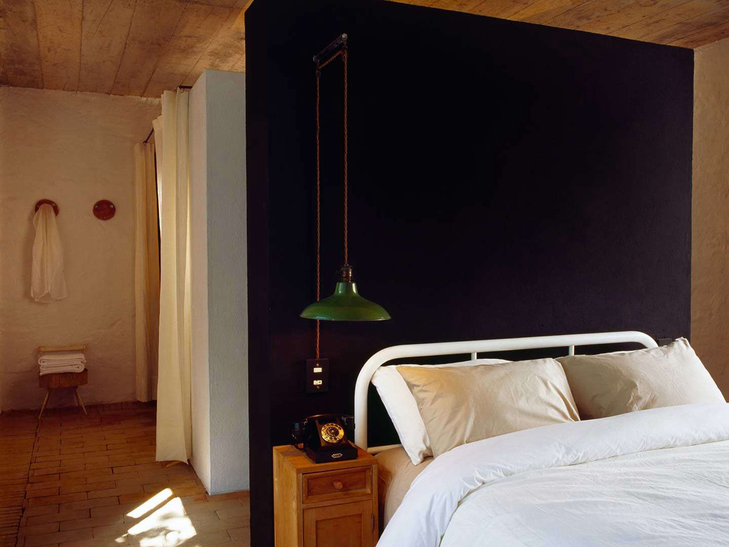 a bedroom features a wrought iron bed in white and a vintage pendant light agai 18