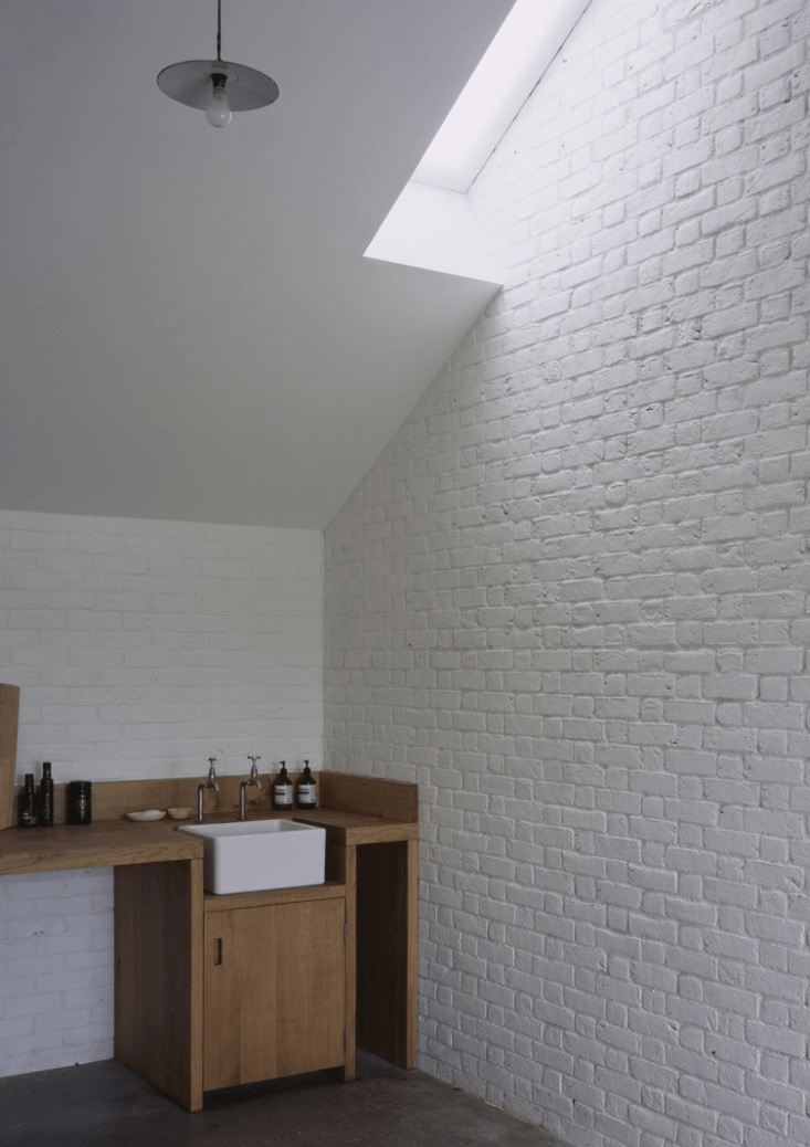 a farmhouse sink is inset in the wood counter; a narrow skylight brings filtere 25