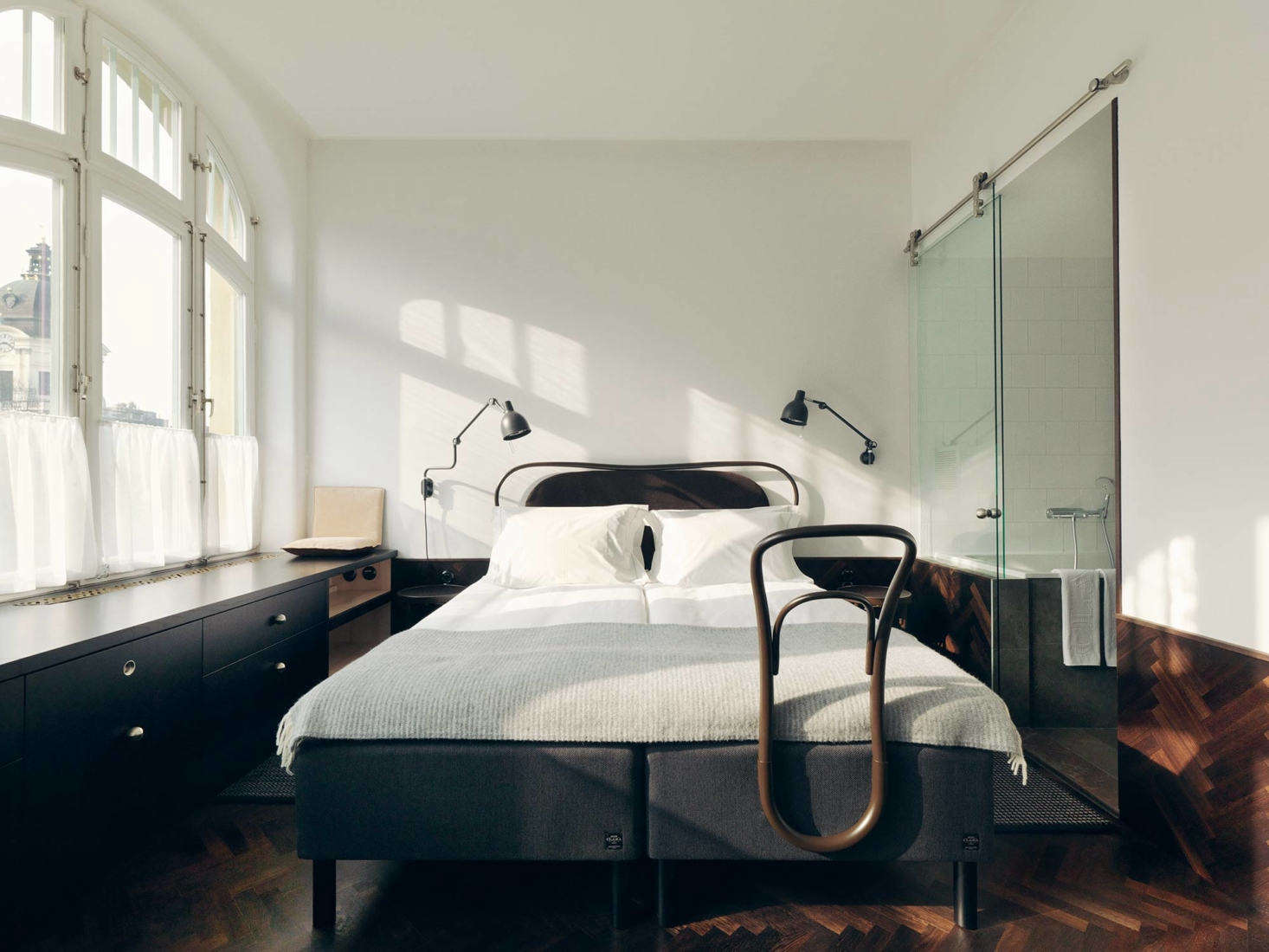 The original building was designed by Swedish architects Hagström & Ekman; the more recent renovations were carried out by award winning architect Gert Wingårdh. While sparsely furnished, the guest rooms are rich in texture. A herringbone-patterned wood floor continues up the walls to form a wainscot. An elegant valet perched at the bottom of the bed is made from bentwood and echoes the form of a Thonet chair.