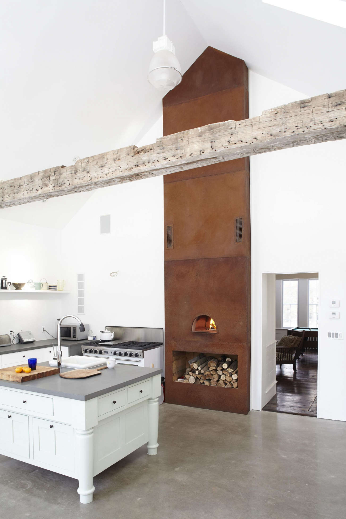 The kitchen has a wood-fired pizza oven faced with oxidized Corten steel. For more on the details of the kitchen see our post Steal This Look: The Ultimate Farmhouse Kitchen.
