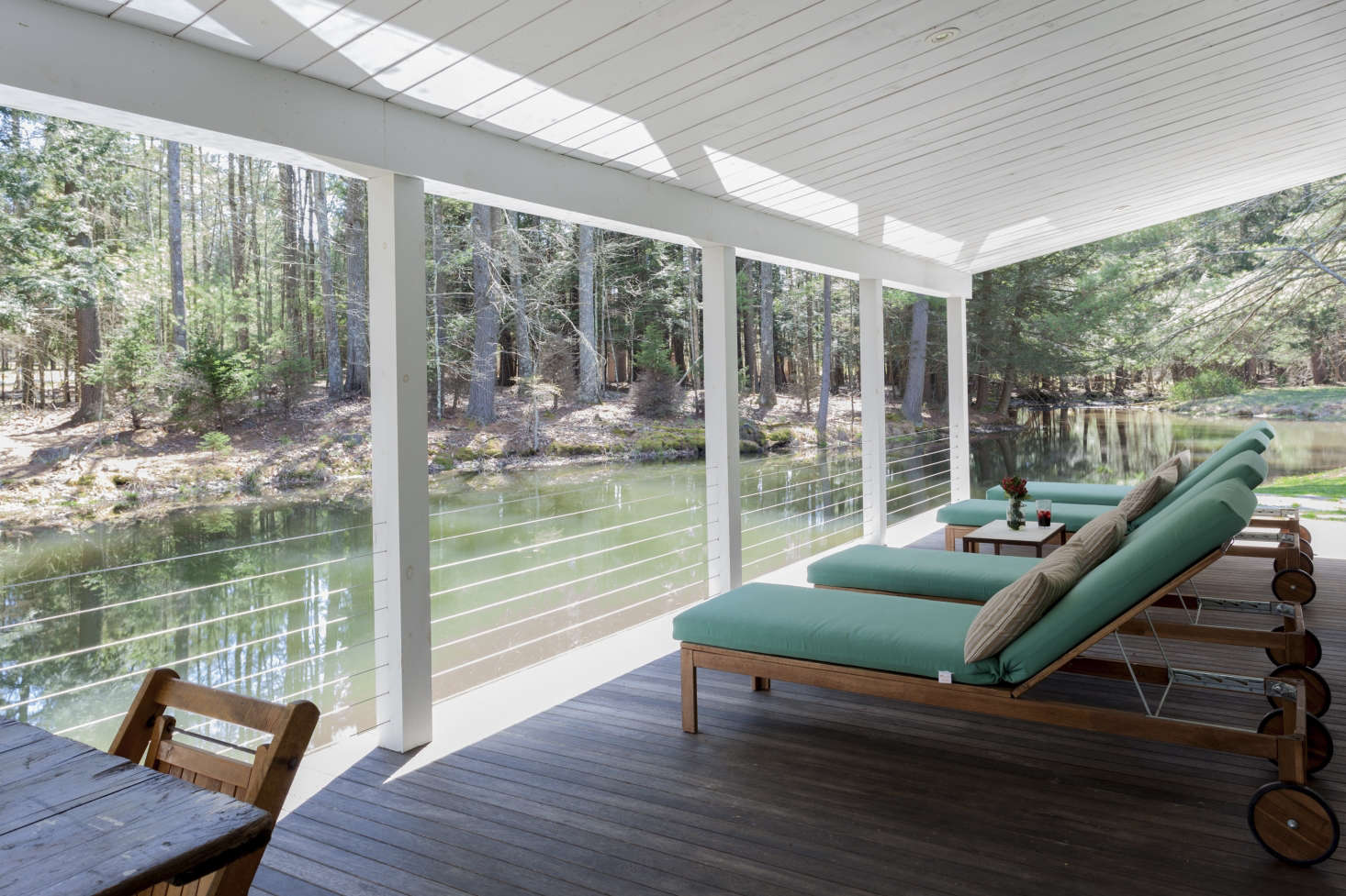 A row of lounge chairs face the water.