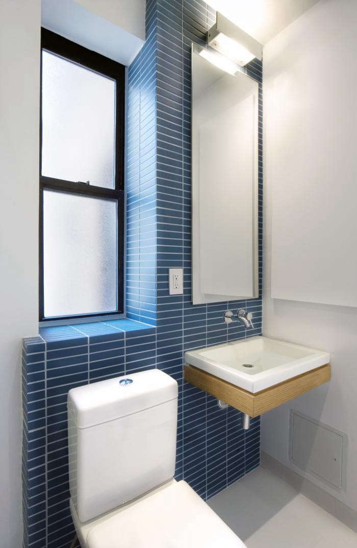 in this small new york bathroom by uniform design, one light fixture performs d 18