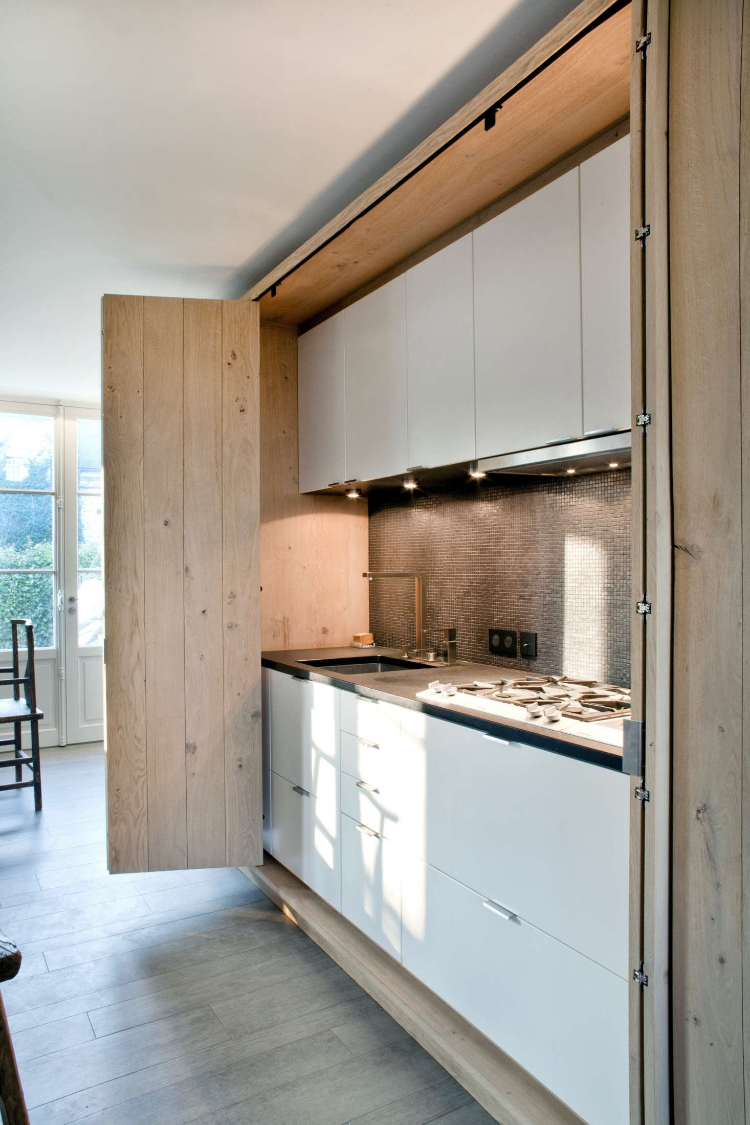 French architect Olivier Chabaud concealed an entire kitchen behind folding doors in this country house.