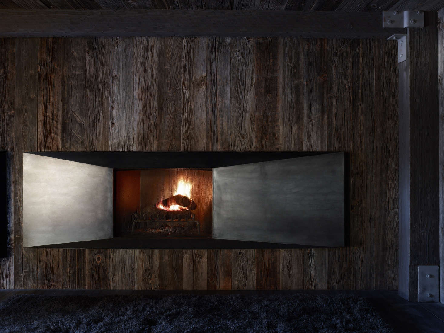 Raw steel doors close off the fireplace when it