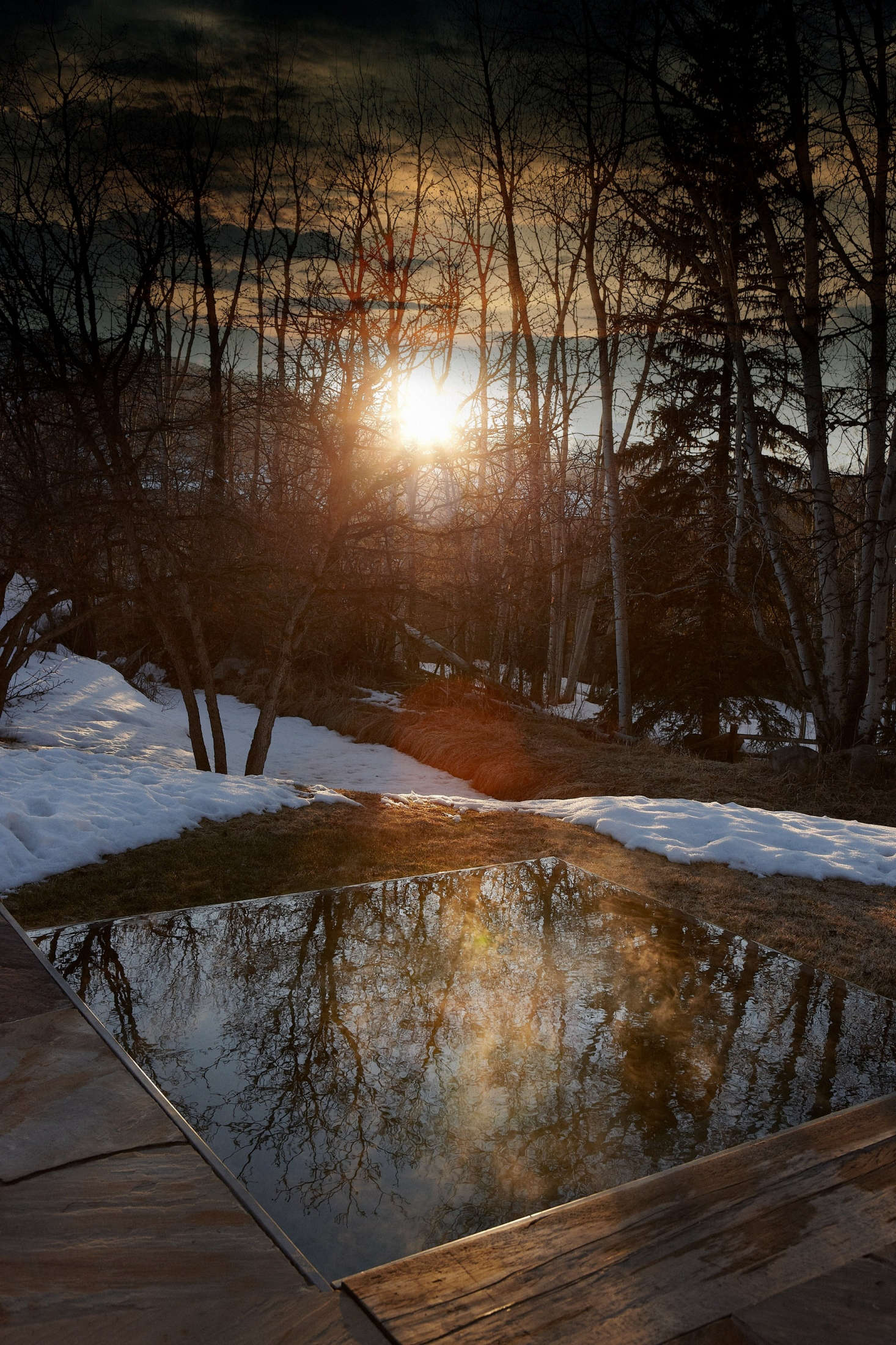 A simple rectangular hot tub is cut into the stone patio.