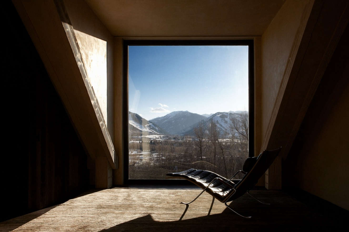 A large window overlooks the mountain range outside.