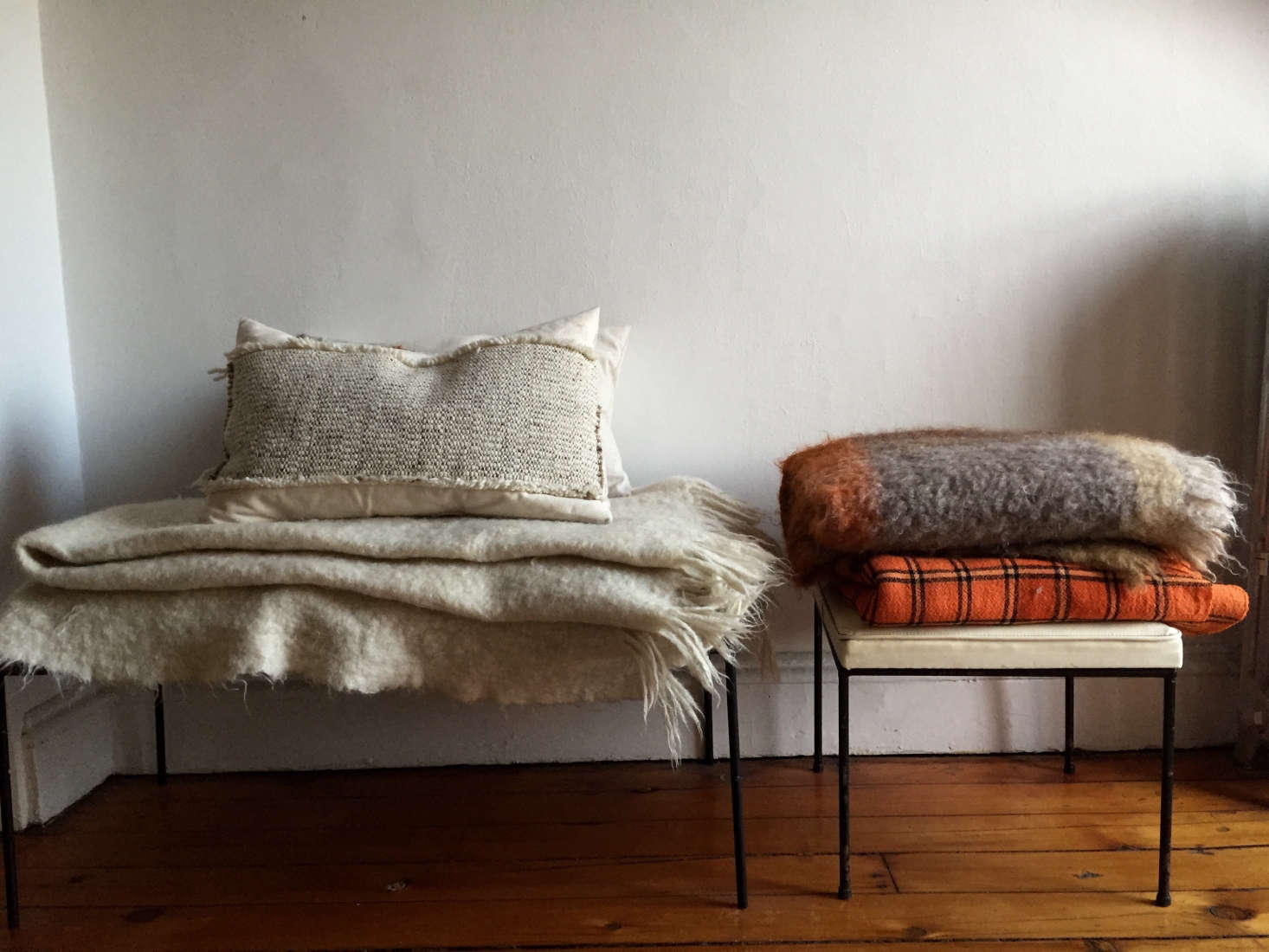 Designer Corinne Gilbert swaps in new textures each season. Here she has cotton, woven linen, felted wool, and angora blankets stacked on stools in the hallway. Photograph by Corinne Gilbert.