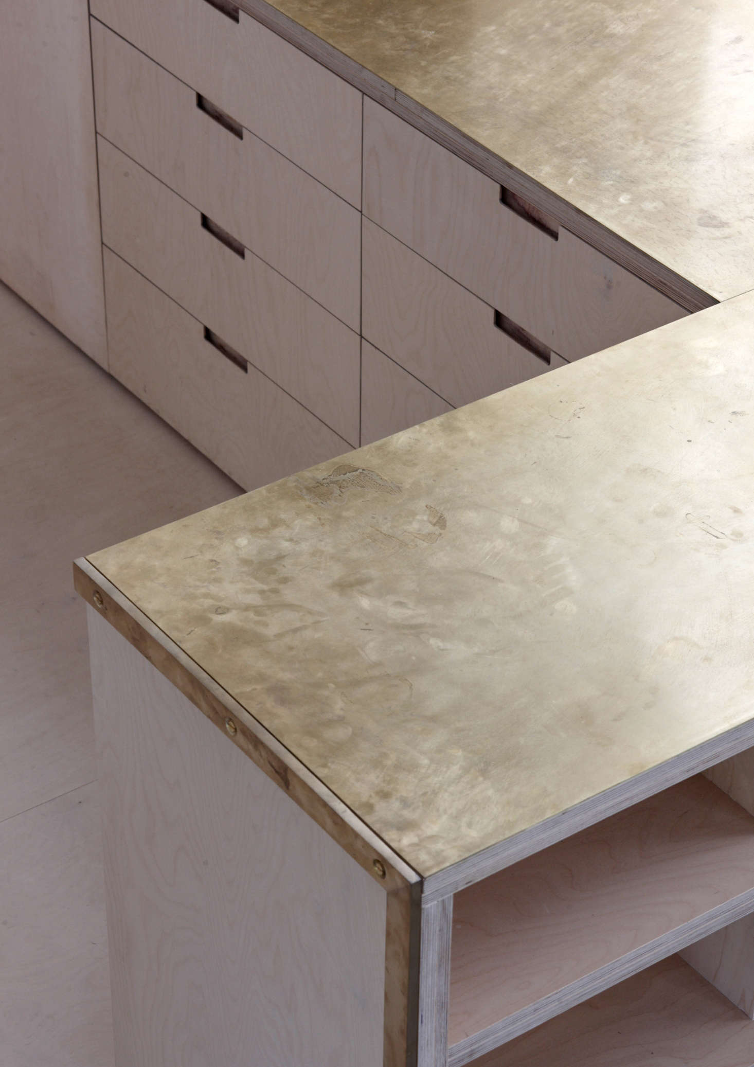 The counters (two layers of mm birch ply bonded with two millimeters of brass: total thickness 38 millimeters) are unlacquered and intended to gather fingerprints and patina over time. All millwork was designed by McLaren Excell and fabricated locally.