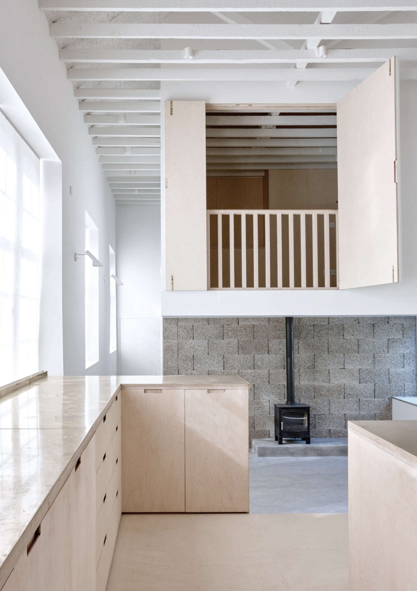 The second-story bedroom—with shutters and railing that open it to the light and life downstairs—appears to float overhead. How were the architects able to pull off this legerdemain?