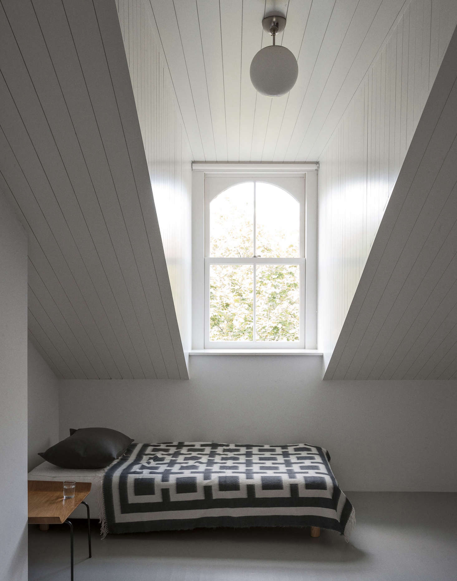 Architects Solveig Fernlund and Neil Logan refurbished a Brooklyn brownstone for a Swedish family. The top-floor guest quarters include this shiplap-paneled room under the eaves. 
