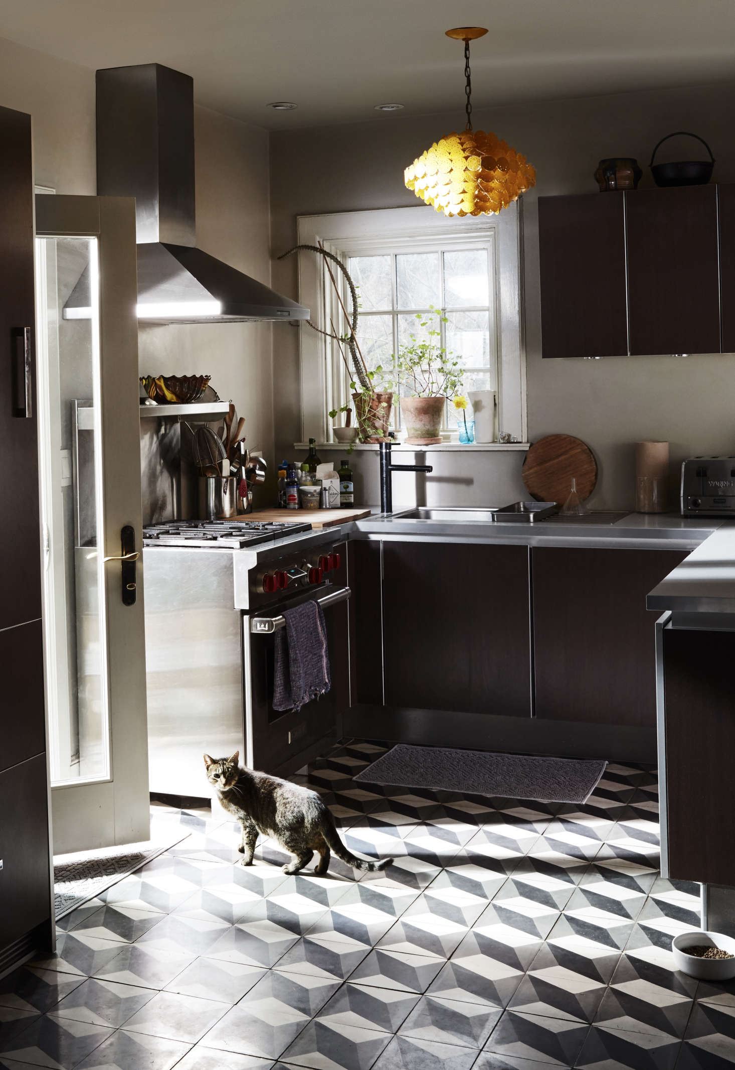 In the kitchen, the couple splurged on a hardware-free design in dark oak with aluminum framing from Poggenpohl
