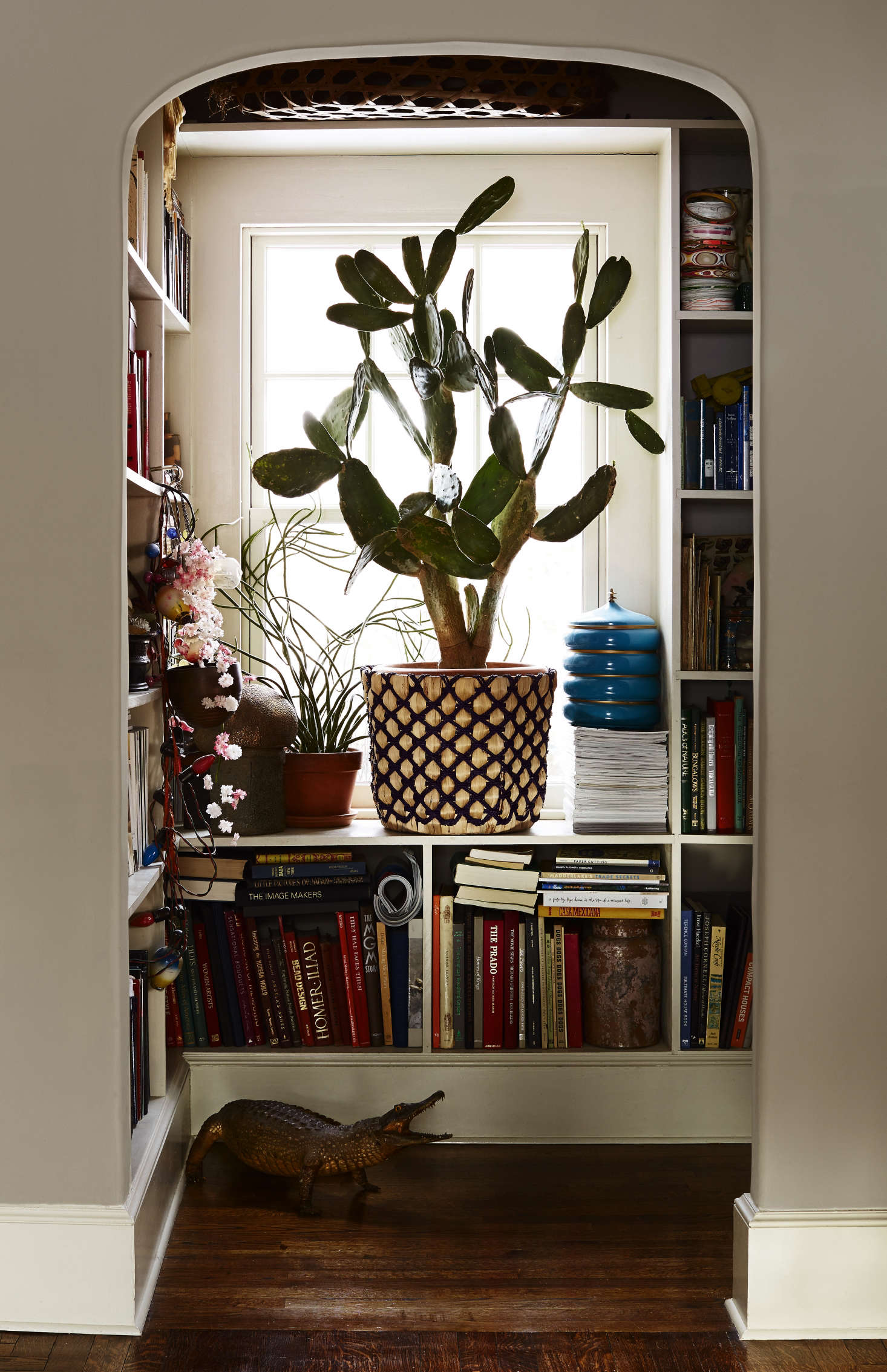 A prickly pear cactus (in a woven palm planter from Target) fills the window of the niche library, formerly the downstairs bathroom. The windows throughout are all new, save for the ones in the sunroom, and are by Pella.