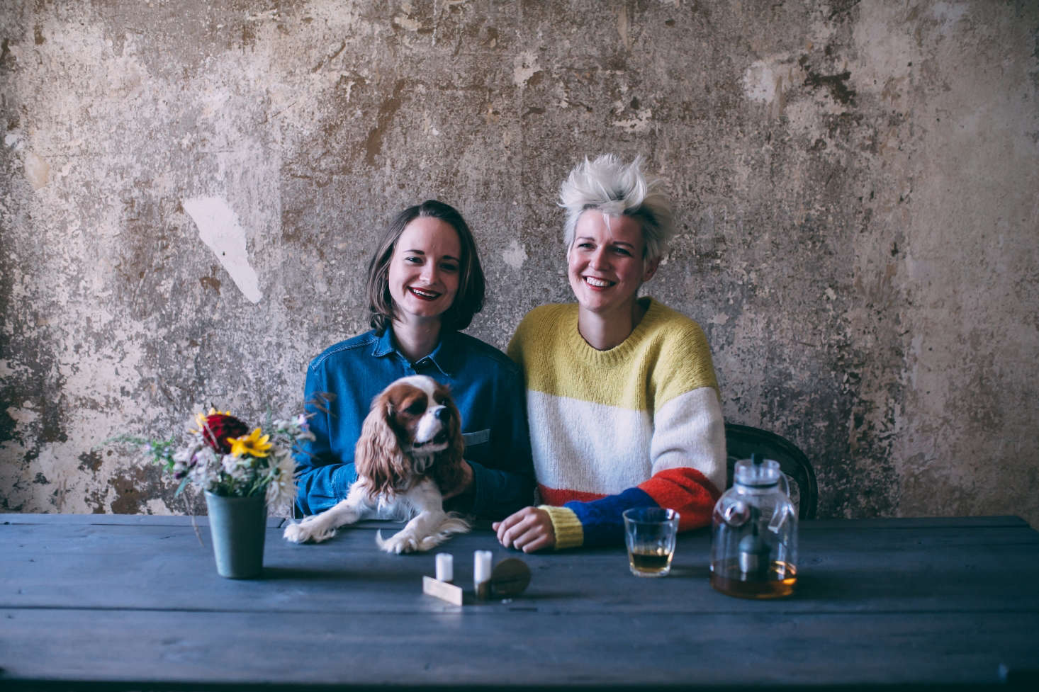 Laura (left) and Nora at their outdoor table with Collin, their Cavalier King Charles spaniel. Just outside their building, they report, there are 