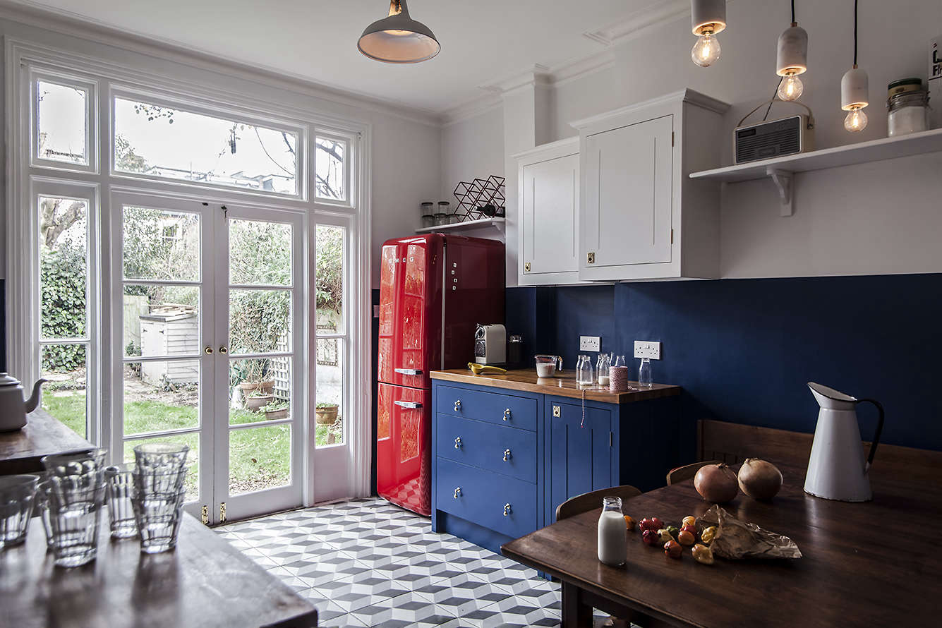 colorful kitchen remodel in london with a red smeg refrigerator and blue britis 18