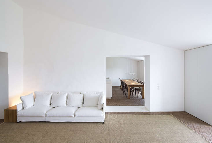 a white sofa sourced from living divani and subtle lighting fixtures by da 20