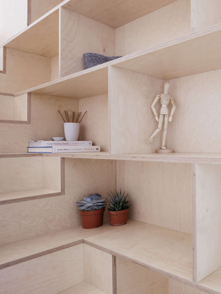 the shelving elegantly wraps around the stairs and the plywood seams are l 24