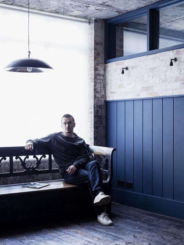 designer mark lewis sits on an antique bench in the office area outside the bed 22