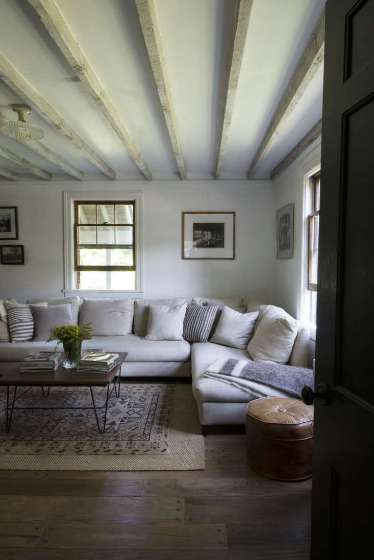 the library has a sectional sofa from housing works paired with a coffee table  20