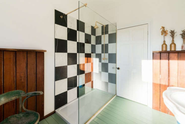  the room has an unexpected glass walled shower that shows off a checkerbo 35