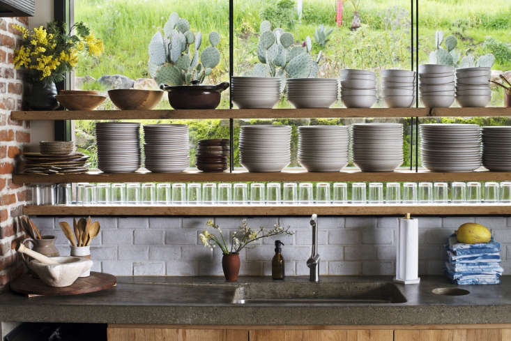 open shelving against a glass window overlooking the vineyard slopes. the shel 23
