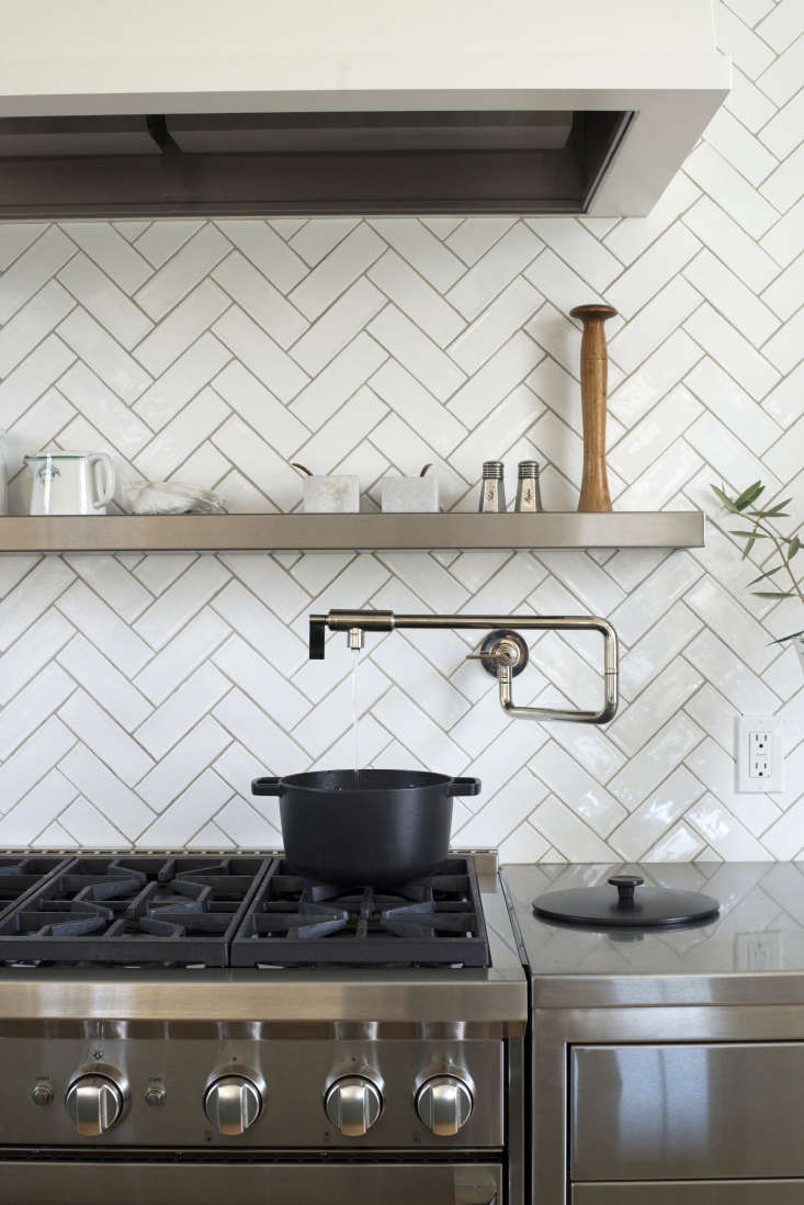 a black pot from crane cookware, perched beneath a pot filler faucet. 33