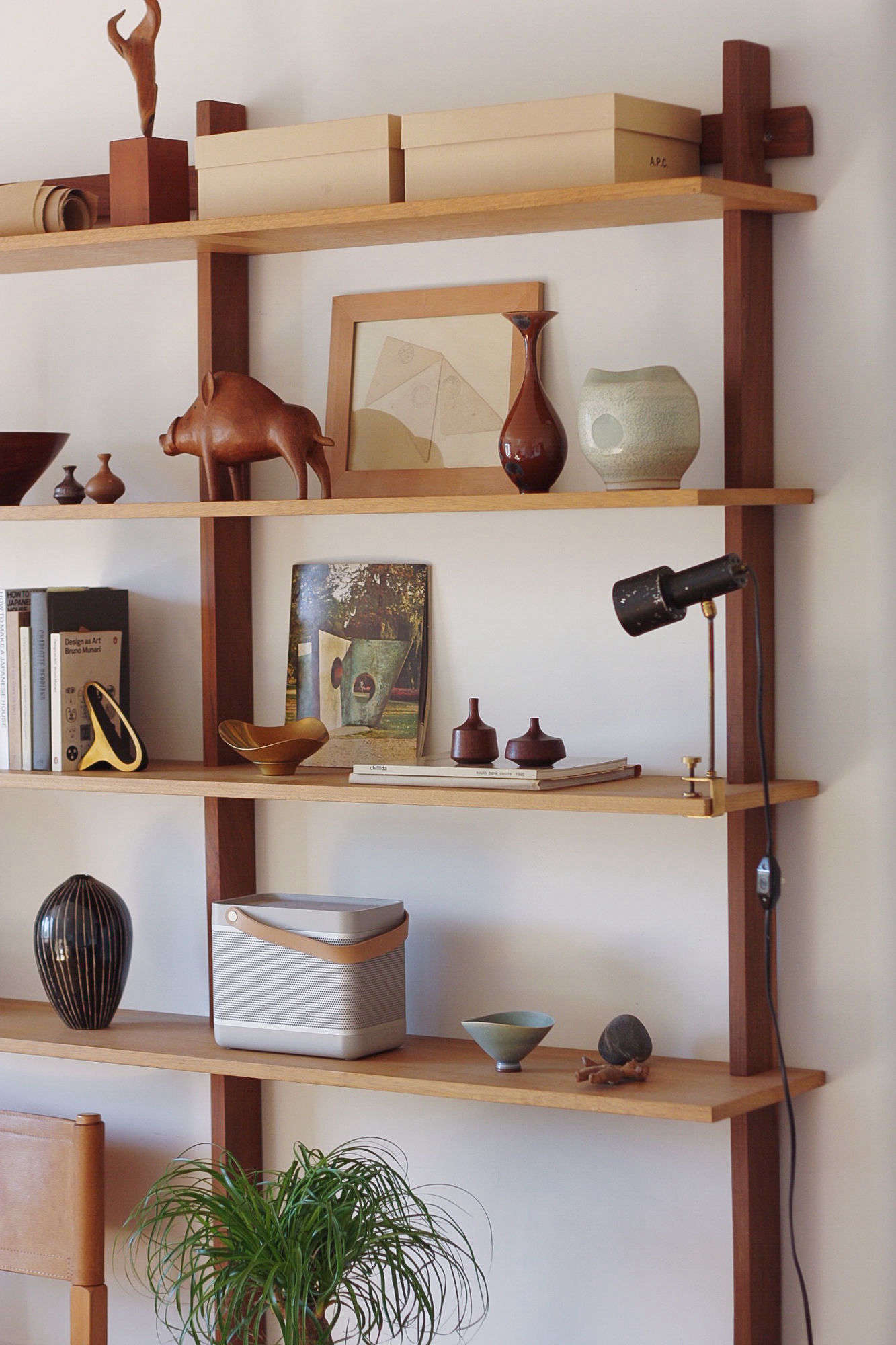 Playful midcentury modern pieces rest on Sticotti Shelving from Design Within Reach.