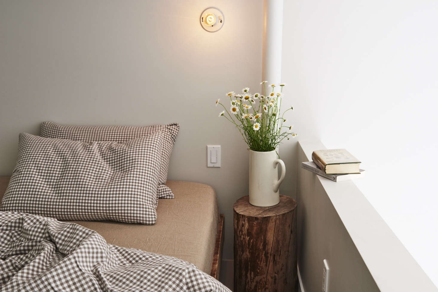 Country chic: checked Muji linens and a pitcher of wildflowers.