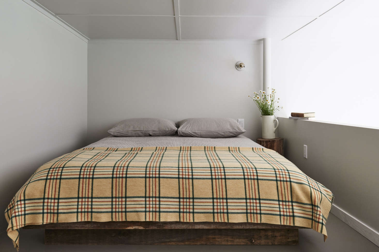 Up a flight of reclaimed-wood stairs: a lofted bedroom that overlooks the living area—and the mountains.