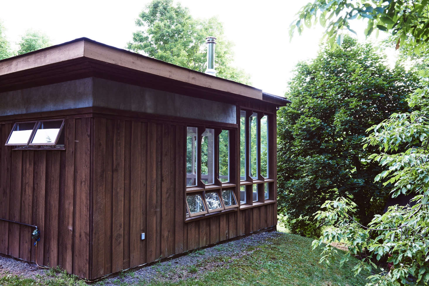 The cabin, shaded by trees.