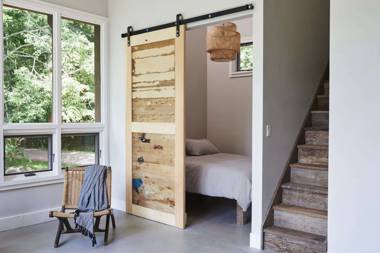 A sliding barn door is made of salvaged wood from the artist