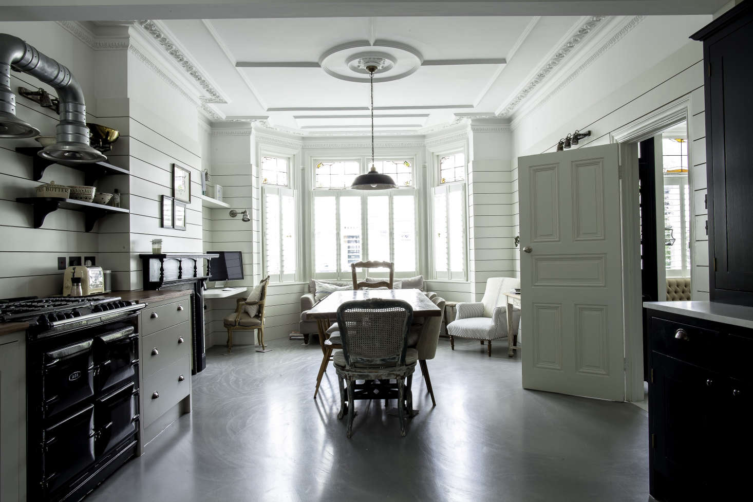 The front of the room, with its large bay window, serves as a hangout area with a desk slotted on one side.
