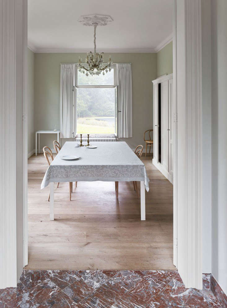 A bare dining room floor reflects summery light from a generous window in the th-century manse of Belgian architects Bram Seghers and Inge Buyse. Photography by Frederik Vercruysse via This Is Paper.