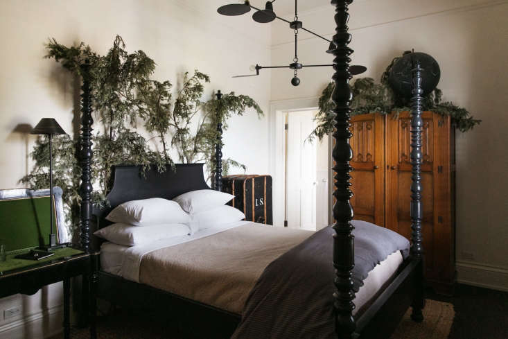 a four poster bed is adorned with foraged branches to create the feeling o 28