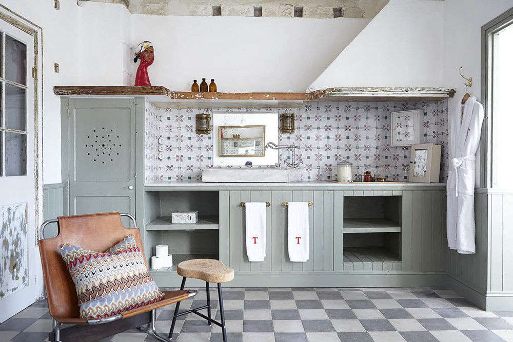The bathrooms are all different; this one has a patterned tile backsplash and painted cabinetry.