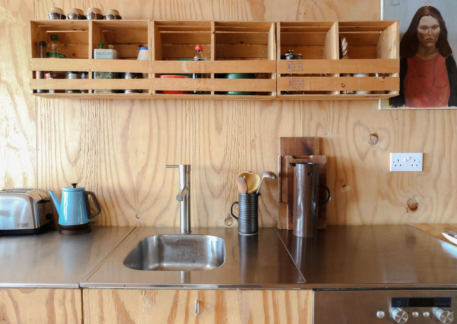 The couple rebuilt the kitchen using Ikea cabinets that they faced with plywood. The stainless steel counter and sink are also from Ikea.