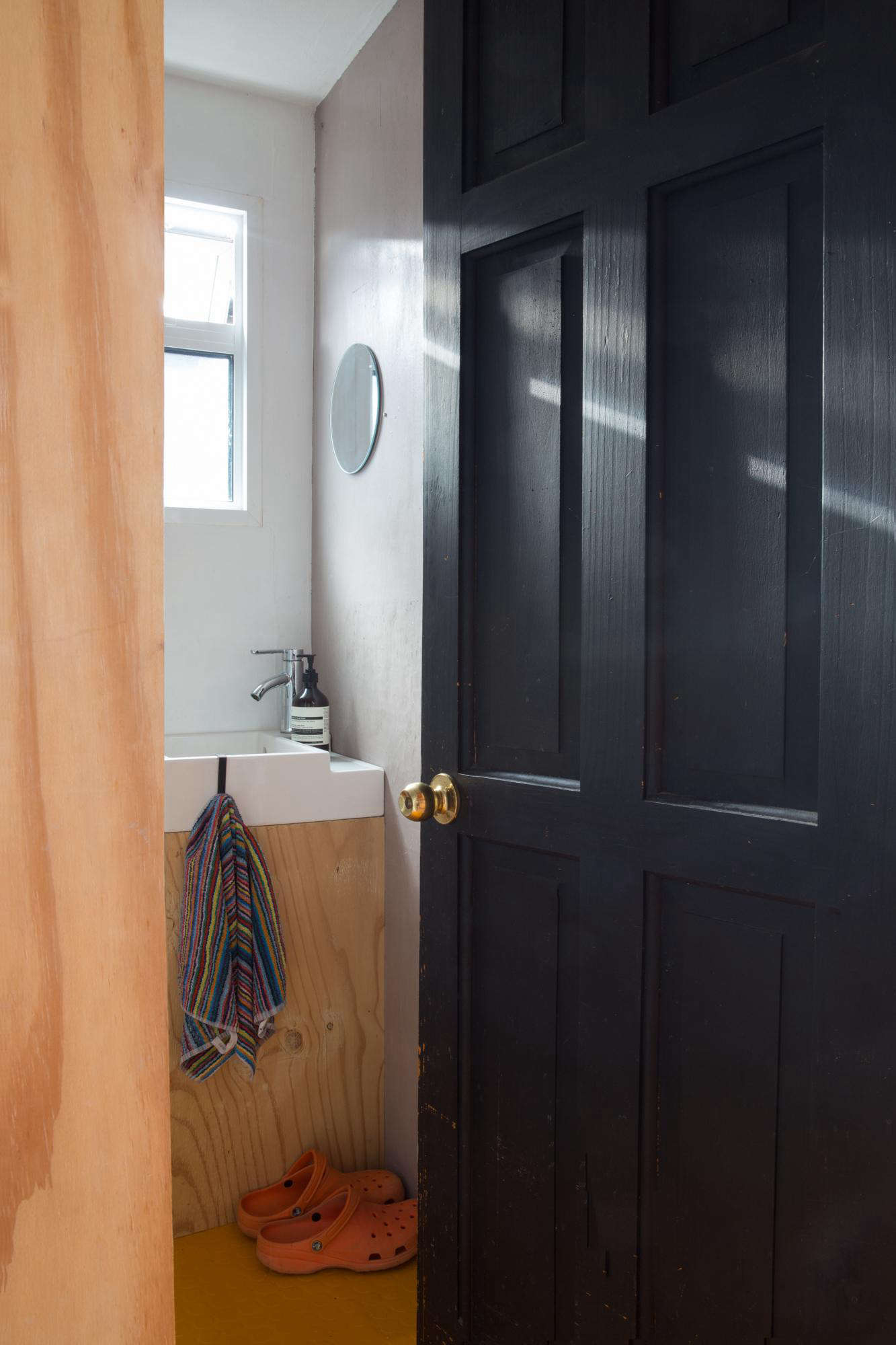 The tiny plywood bathroom has just enough room for the door to open. 