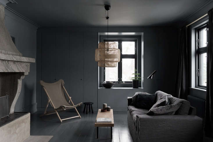 dark gray paint surrounds the living room, from a painted wood floor to the wal 17