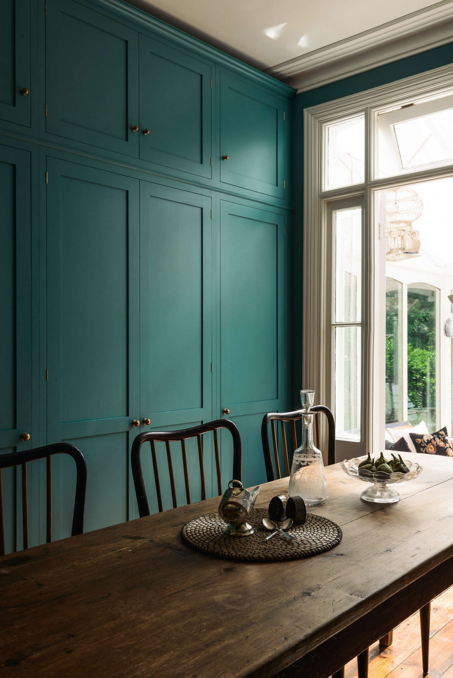 Original French doors open to a conservatory overlooking the terrace and garden.