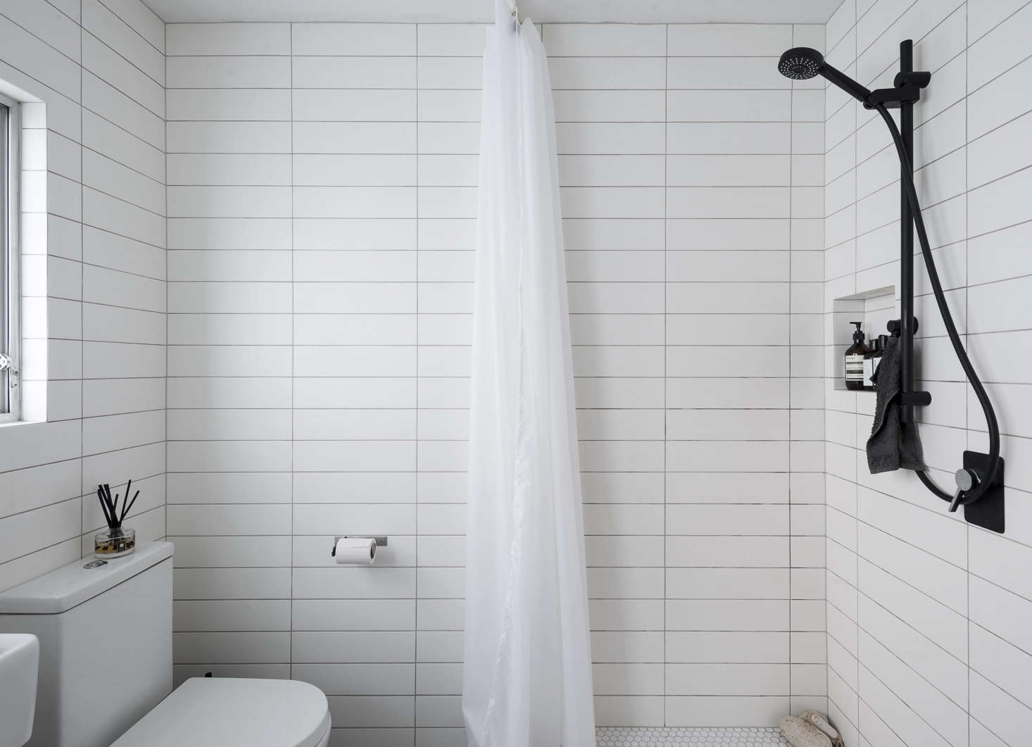A shower curtain replaces the clunky glass enclosure from before. A black and white palette keeps the small space clean-lined but a little edgy: Spath sourced the white white subway tiles from Tile Space and the matte black fixtures from The Kitchen Hub, both in Auckland.
