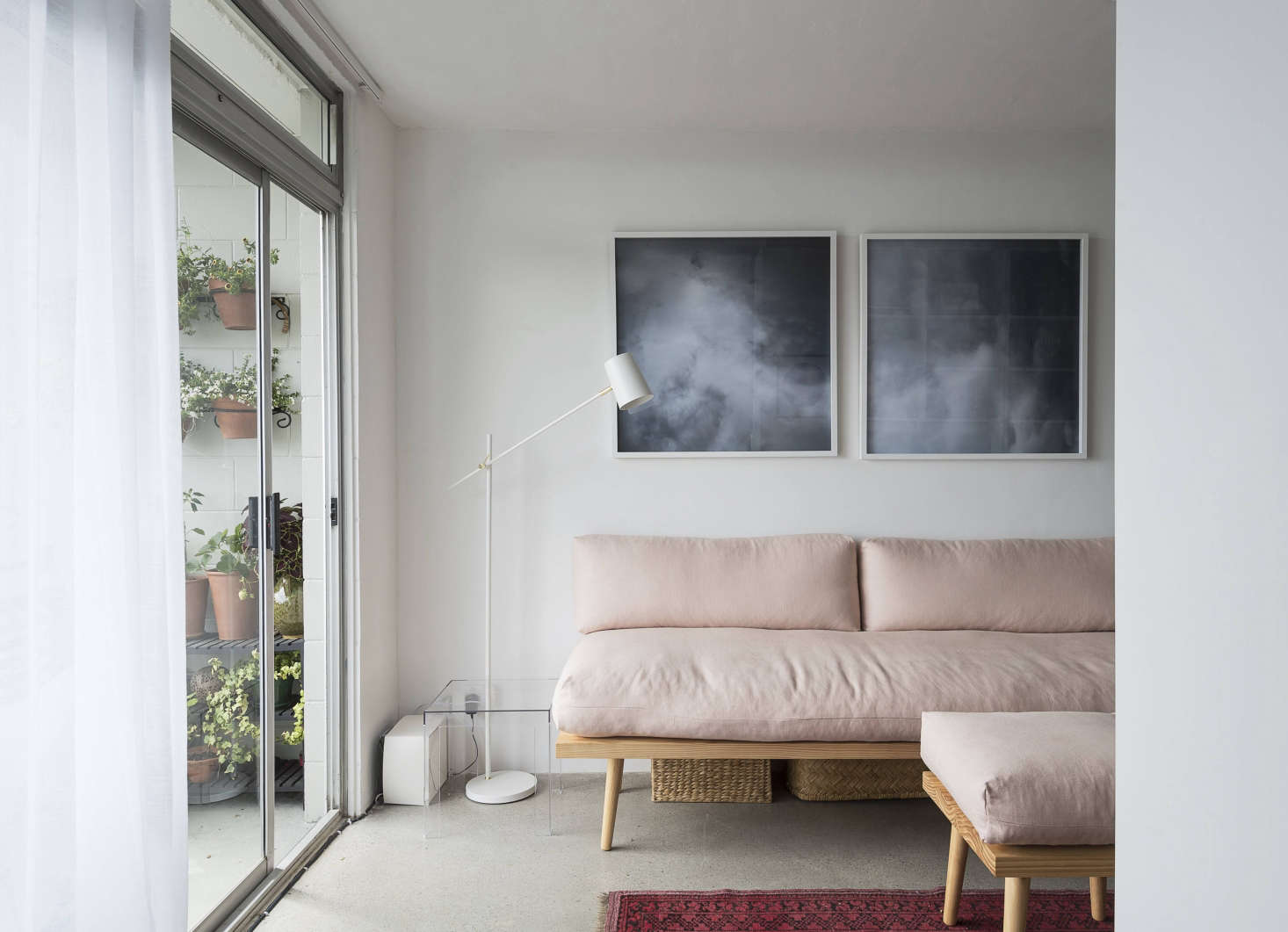 Despite its small footprint, the living room feels airy and open thanks to furniture with simple lines, a dark rug, and judicious edits: 