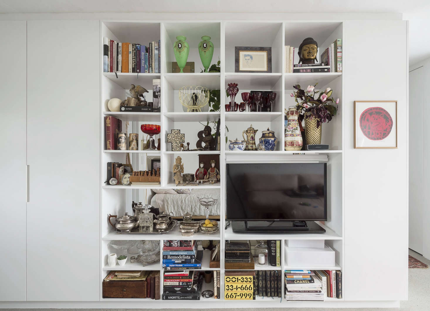To create the illusion of a wall between living room and bedroom without building a wall, Spath added custom-built shelving. The client
