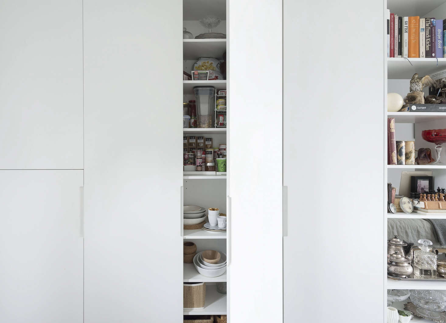 Floor-to-ceiling cabinets conceal dinnerware and dry goods.