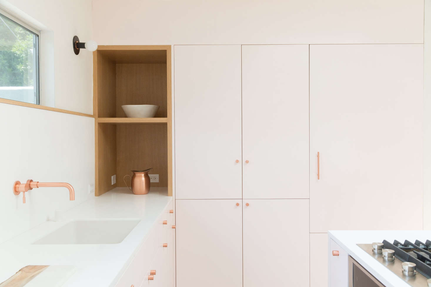 To keep the counters clear, the architects incorporated plenty of closed storage. The refrigerator is concealed behind a wall of flush cabinetry inset with an oak appliance nook.
