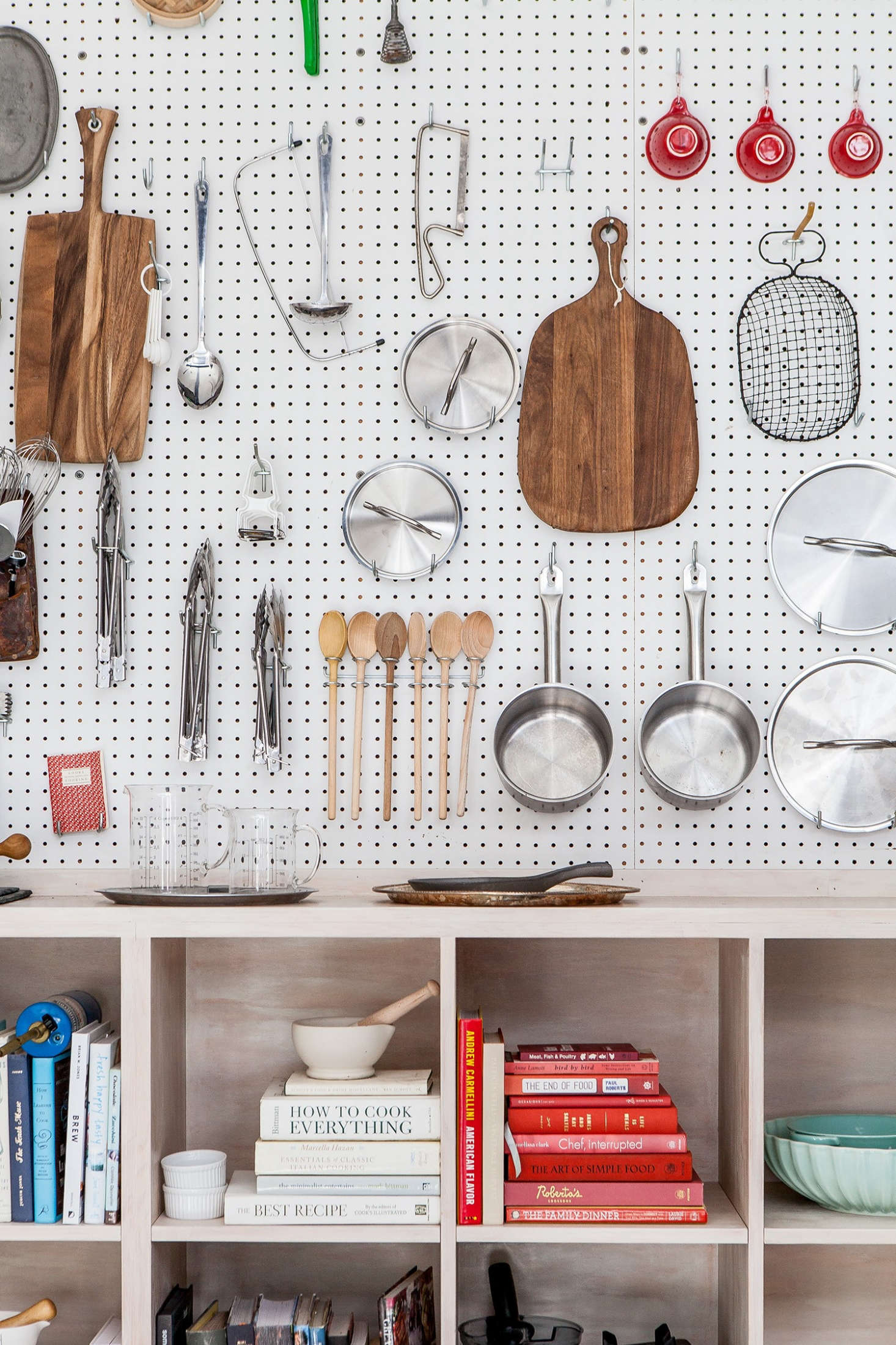 An ever versatile pegboard hangs above cubbies, built by a neighboring tenant.