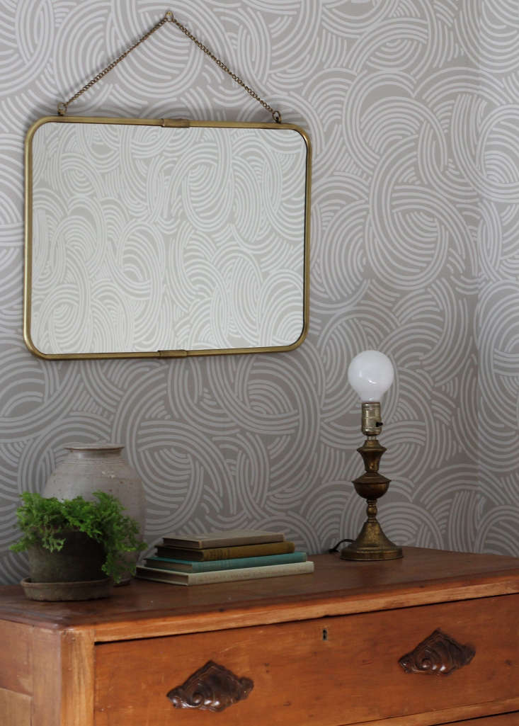 a vintage chest of drawers is paired with a brass framed mirror (since disconti 38