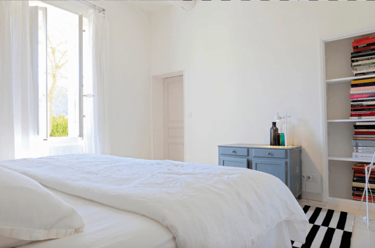 the bold chambre bastine, with lofty ceilings, a black and white rug, and a vig 27