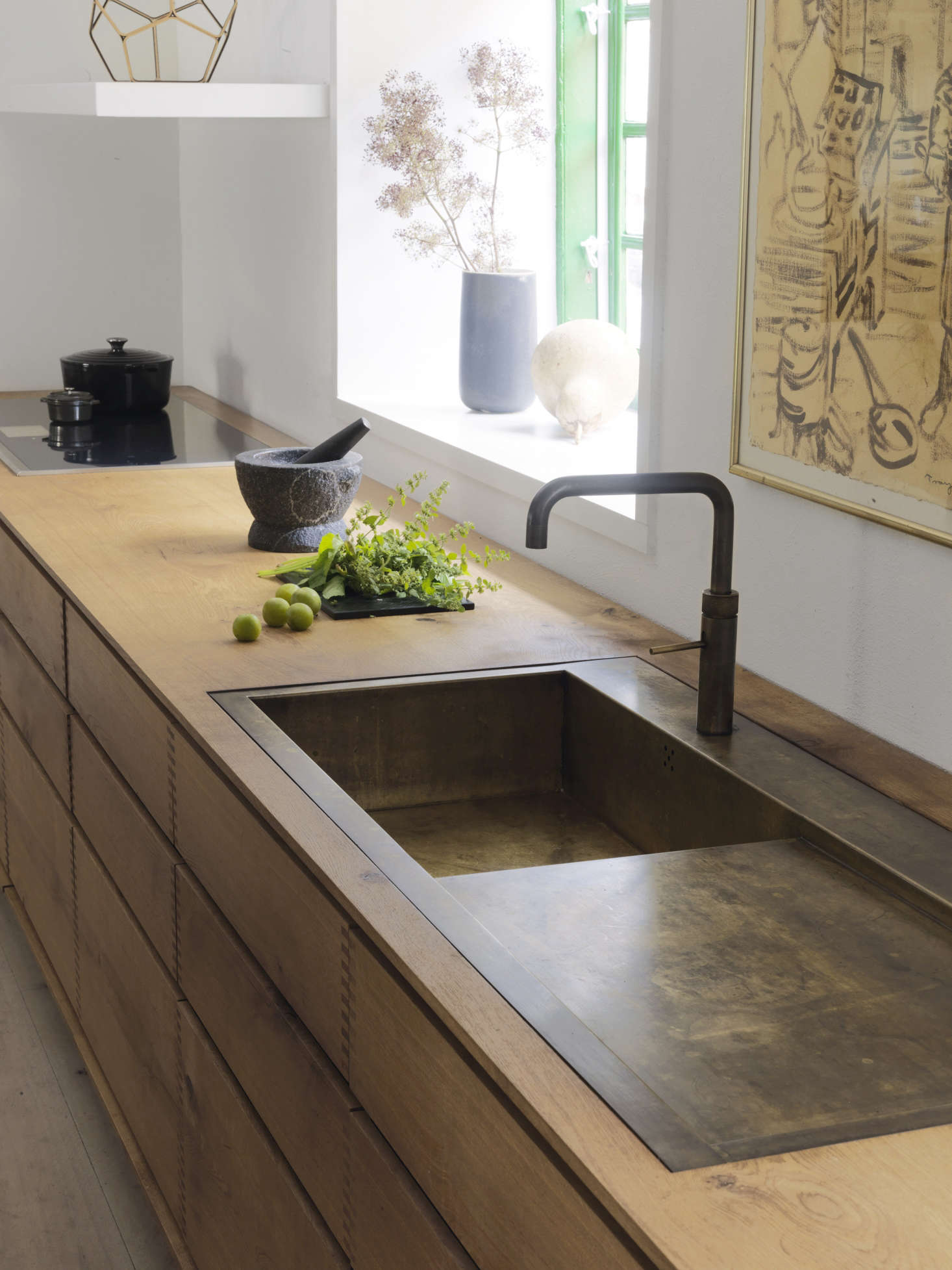 A weathered brass sink is integrated with the spacious countertop.