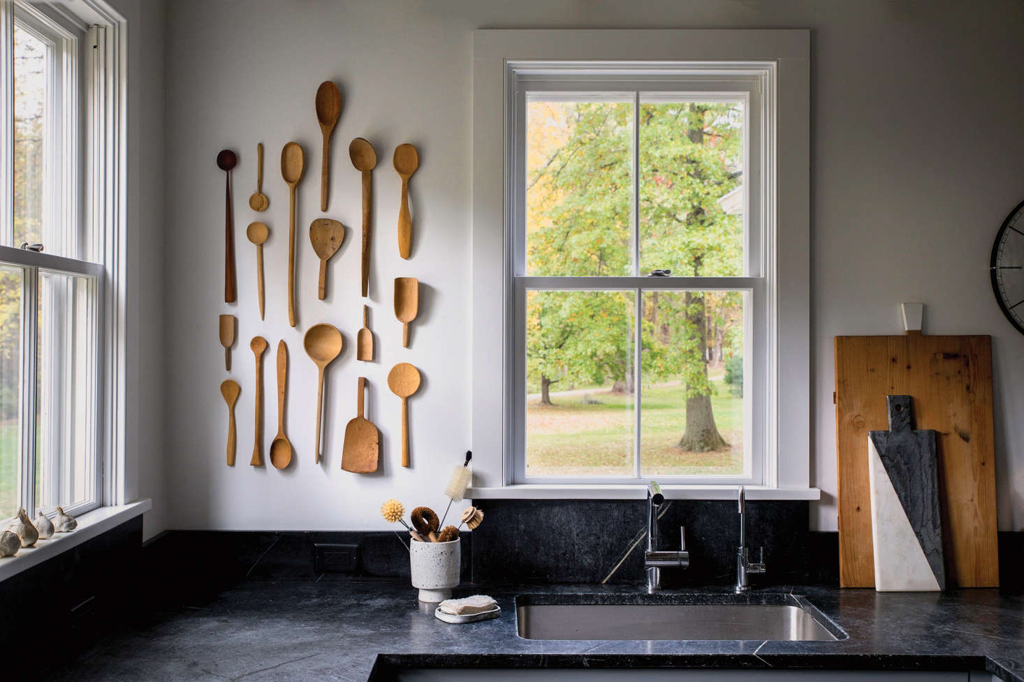 For the dramatic dark countertops, Dunja chose traditional soapstone from Barra & Trumbore in Kerhonkson, New York. Her wooden spoon installation is comprised of vintage pieces procured on Etsy and eBay. Dunja, who is a textile designer as well as a potter, made the soap dish.