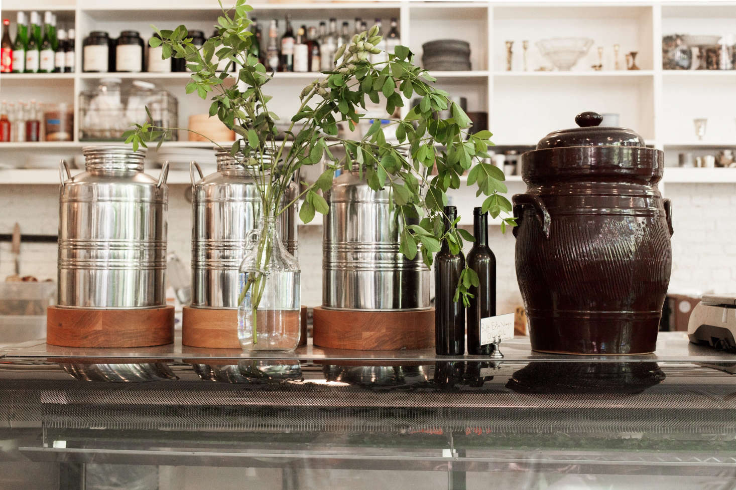 Three Italian stainless steel fustis, whose original purpose is to store olive oil, evoke Mediterranean climates.