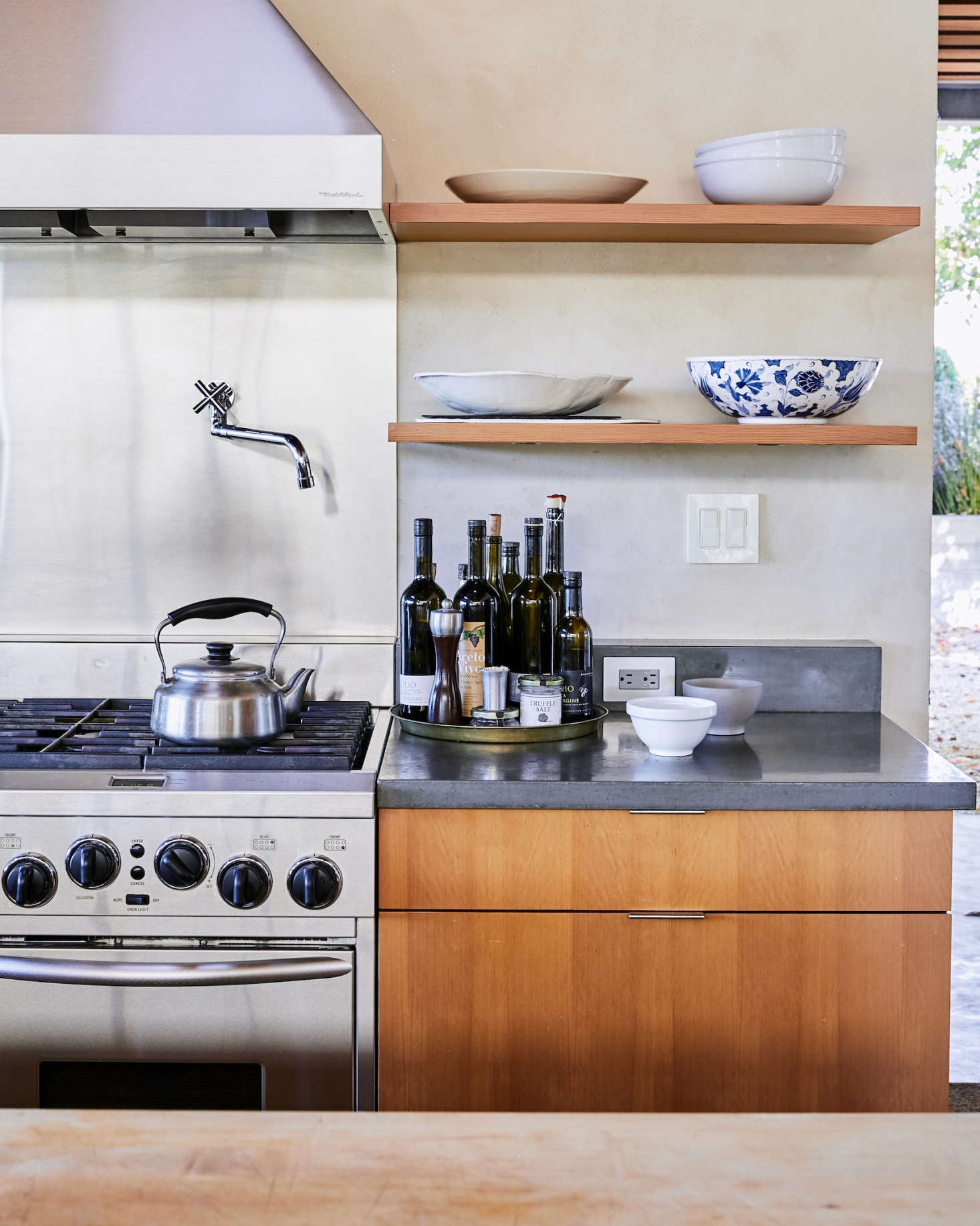 The surrounding kitchen countertops are dark gray concrete. Within easy reach for cooking: Baker Lane Estate Tuscan Olive Oil ($) and Aceto Vivo vinegar ($). Of Baker Lane olive oils, the winemaker says, “We don’t make a lot, but it’s really good.